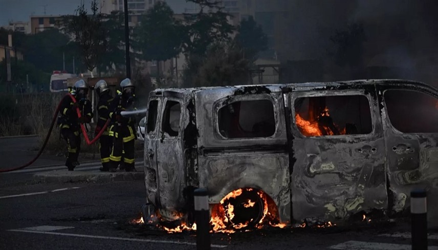 إطفائيون حول سيارات متفحمة في نانتير قرب باريس مساء أمس الأربعاء (أ ف ب)